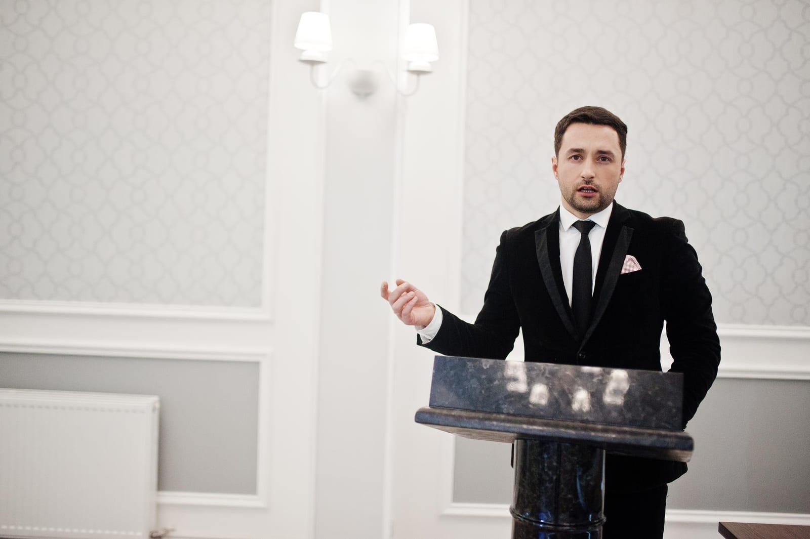 Relatore in abito elegante che parla da un podio